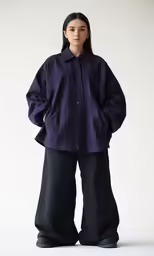a model in a purple jacket, black pants and shoes