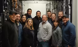 a group of people standing together in front of servers