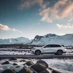 a white car parked on the side of the road in winter