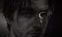 a young man with dark makeup staring into the camera