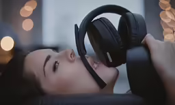 there is a woman wearing headphones laying on the chair