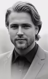 a man in black and white is looking at the camera