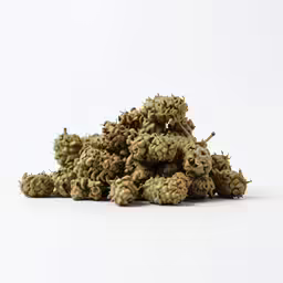 a pile of green plants sitting on top of a white table
