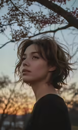 a close - up of a girl posing in front of a tree