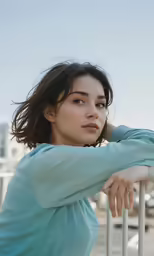 a woman leaning on a rail looking over her shoulder