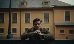 a man poses in front of a building