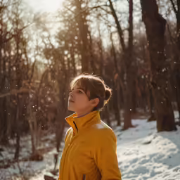 the woman wearing the yellow jacket looks into the distance