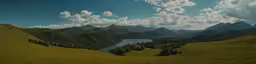 a scenic landscape of hills and lake surrounded by forest
