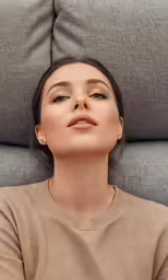 a young woman sitting on a couch looking up