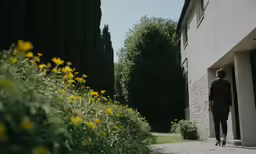 a man walking down a sidewalk towards a building