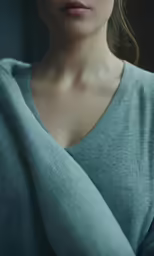 a woman is posing for a photo while wearing a gray shirt