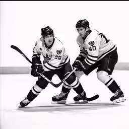 two hockey players going for the puck in a game