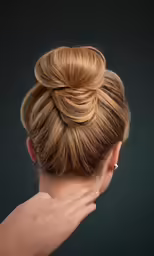 a woman in a high bun with gold hair