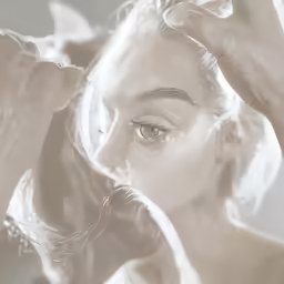 a woman putting on her hair, posing