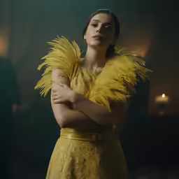 woman in yellow dress with arms crossed posing for picture