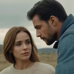 two people wearing sweaters and ties stand on the plains