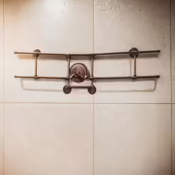 a metal rack is attached to a tiled wall