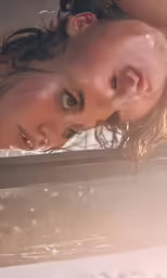 a girl posing and looking out the window in her swimming pool