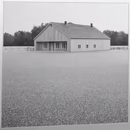 a barn with a large open field behind it