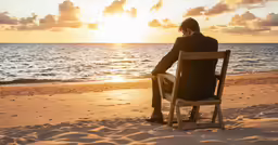 a person sitting in a chair looking out to sea