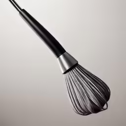 a black and silver wire whisk is attached to a silver object