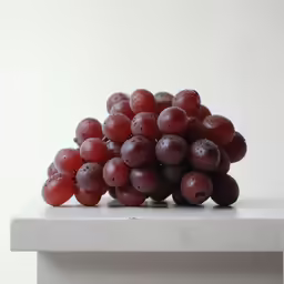 a bunch of grapes on a table with water drops