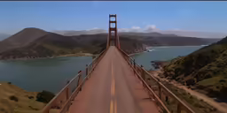 a bridge spans the width of two mountains in front of water and hills