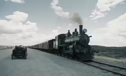 an old time steam train driving down the tracks