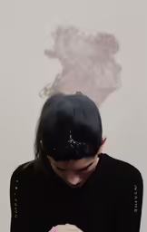 a woman with black hair and dark eyes in a black shirt, using her cell phone