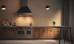 a kitchen with two lamps that are above the stove