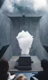 people look up at a sculpture with a fog billowing from it