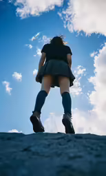 a woman in short skirt and boots standing on a beach