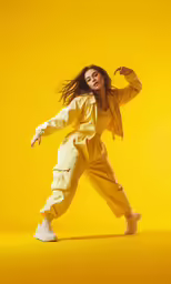 a woman in a yellow outfit is dancing
