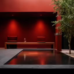 a large wooden table and two chairs against a red wall