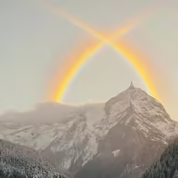 the rainbow appears over the snowy mountains to symbol peace