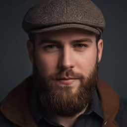 the bearded man with a beard is dressed in a cap