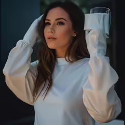 a woman wearing a white dress and holding a glass of wine