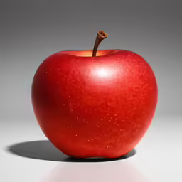 an apple sitting on top of a table next to a silver background
