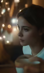 the woman is holding a coffee mug with a blurry image in the background
