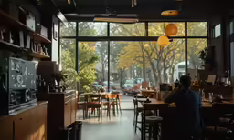 people sitting at tables with lots of chairs in a coffee shop