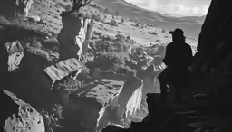 a man standing on the top of a mountain watching a view