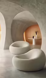 two oval seating is sitting in a white room