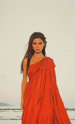 a woman wearing an orange draped dress and sandals
