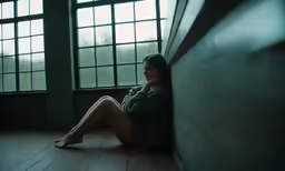 woman sitting on floor in front of window at night