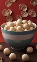 a bowl of white cookies is shown with more doughnuts and pieces of brown icing next to it