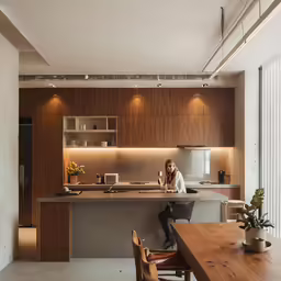 the kitchen features large wooden cabinets, an island and a large counter