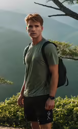 a man standing in the woods holding a bag