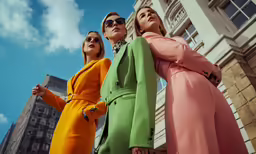 three female in various colors are standing together