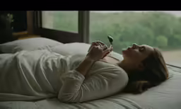 there is a woman lying down and holding a flower in her hand
