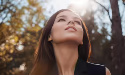 a woman wearing a black shirt is looking upward